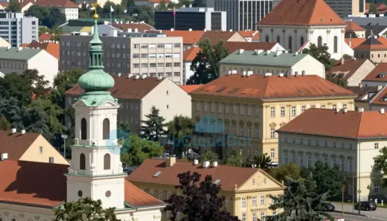 A scenic view of Miskolc, Hungary, showing the city skyline with prominent buildings and landmarks, nestled in the Northern (Észak) region, with clear skies and natural daylight, possibly including the Bükk Mountains in the background