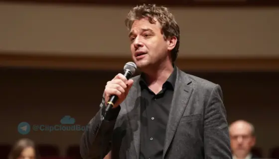 A portrait of János Elek Mészáros performing on stage at a concert in Miskolc, holding a microphone, with warm stage lighting, a subtle background of a concert hall with blurred audience and musical instruments, expressing emotion through his singing, realistic details in clothing and facial expression