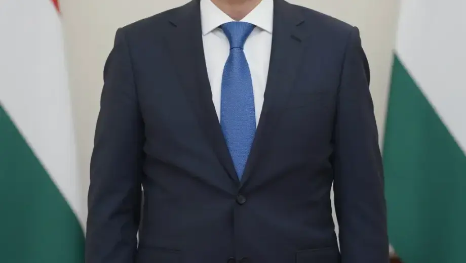 A formal portrait of a middle-aged Hungarian man in a suit, standing in a dignified pose with a serious expression, set against a classic office background with a wooden desk and a Hungarian flag in the corner, conveying respect and authority