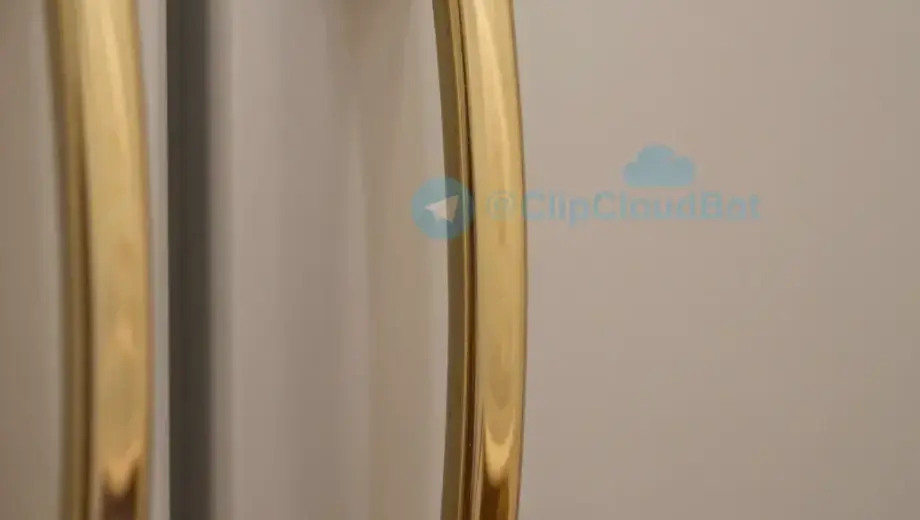 A close-up view of a refrigerator door handle made of gold, with intricate details and a polished finish. The handle should be the main focus, with a soft, warm lighting that highlights its luxurious appearance.