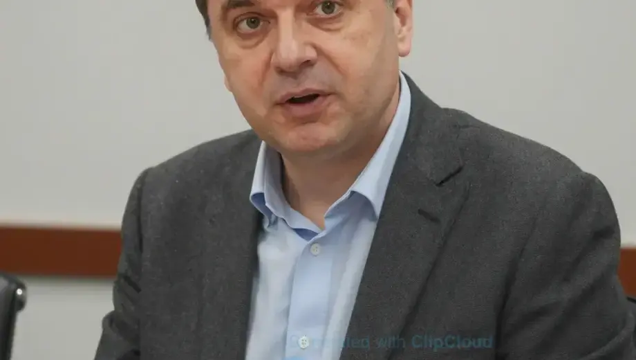 A high-quality portrait of Szabó Gyöző, a Hungarian personality, in a professional setting, possibly a studio or a conference room, with a neutral background. He should be depicted in a modern, well-lit environment, wearing professional attire, and looking engaged and thoughtful.