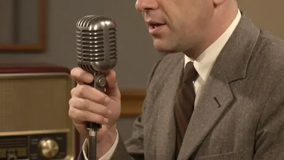 A vintage-style radio studio scene with a man in a suit (Hildebrand Krisztián) speaking into a classic microphone, surrounded by vintage audio equipment and warm lighting, evoking a 1950s Hungarian radio broadcast atmosphere