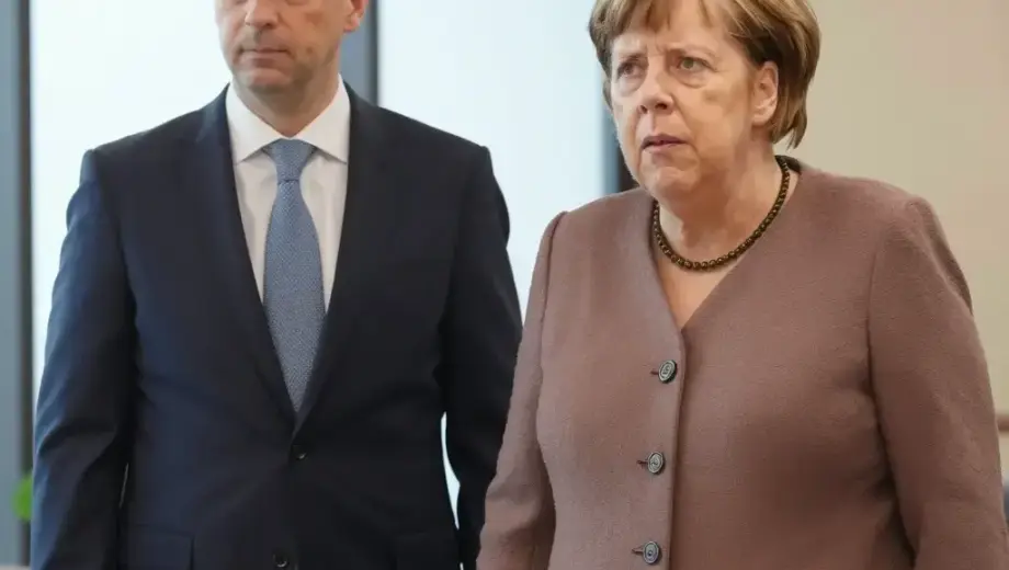 Angela Merkel and Vladimir Putin standing together in a formal meeting setting, with Merkel appearing concerned or frustrated while Putin looks confident, modern office or conference room background, professional attire, serious atmosphere
