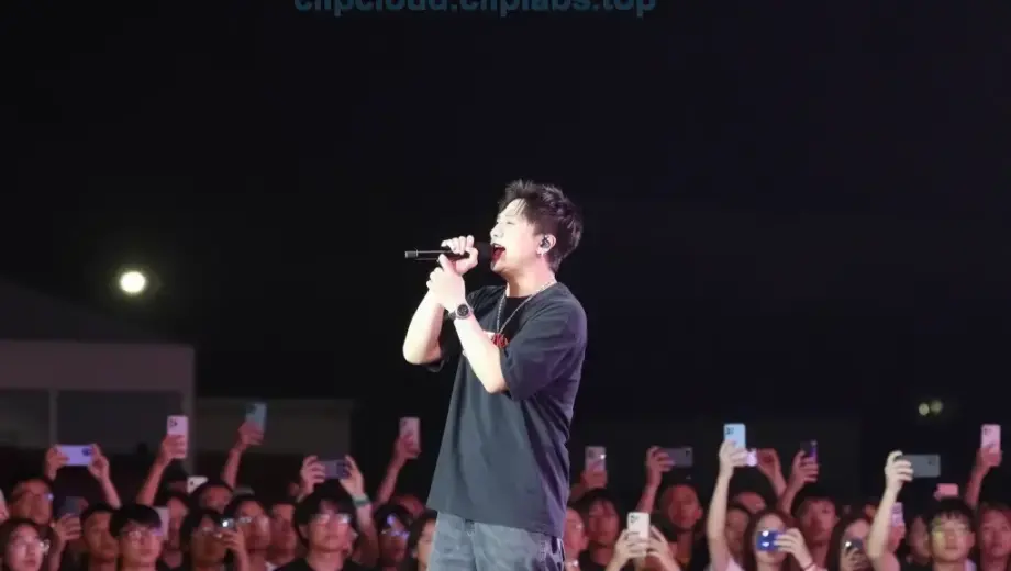 A dramatic concert stage at night with a large crowd of people, a central performer singing passionately into a microphone, colorful stage lights illuminating the scene, and a dark sky above