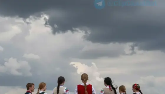 A dramatic scene showing a group of people in traditional Hungarian folk costumes standing on a windswept hilltop, looking out over a vast, empty plain where their partners have departed. The sky is filled with swirling storm clouds, and the figures' garments are billowing in the wind, conveying a sense of farewell and melancholy. The composition emphasizes the emotional weight of the moment with a focus on the silhouettes against the horizon.
