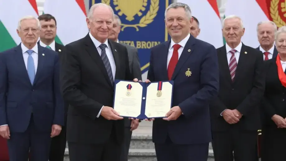 A formal ceremony in Borsod-Abaúj-Zemplén, Hungary, where local residents receive official state honors, with dignitaries presenting certificates or medals in a grand hall or outdoor plaza, Hungarian flags and official banners visible, people in formal attire smiling and receiving awards, diverse group of adults and elders, dignified and celebratory atmosphere