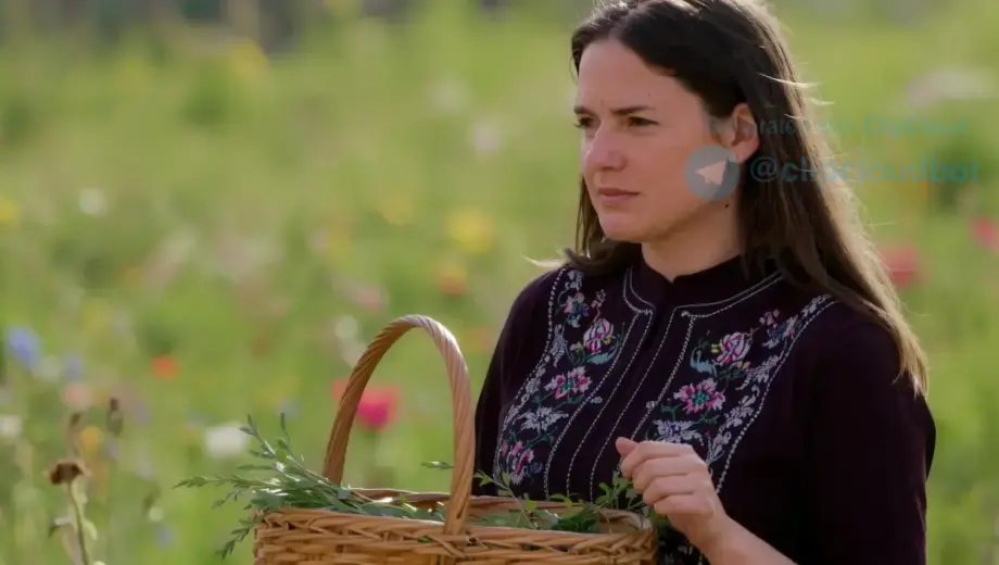 A realistic portrait of a Hungarian woman in her 30s, wearing traditional folk attire with intricate embroidery, standing in a sunlit field of wildflowers, holding a woven basket of herbs, soft natural lighting, shallow depth of field, detailed facial expression showing contemplation