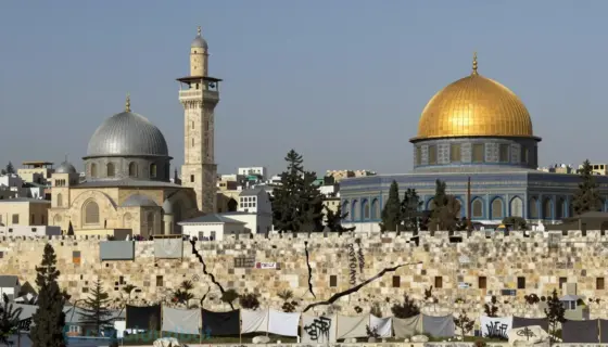 A symbolic contrast between Damascus and Jerusalem, showing two ancient city skylines facing each other across a divided landscape — on one side, the domes and minarets of Damascus with warm ochre and sandstone tones, on the other, the stone walls and golden domes of Jerusalem under a clear sky; between them, a fractured barrier with subtle signs of protest — empty banners, scattered stones, and faint graffiti-like marks of resistance — rendered in a solemn, realistic style with muted earth tone