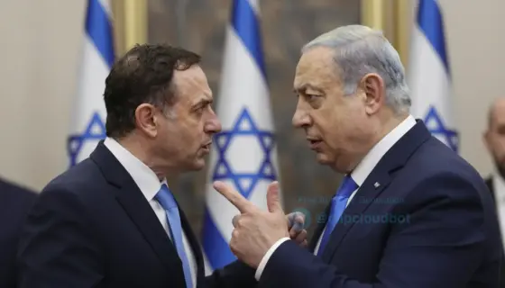 A dramatic political scene showing Israeli National Security Minister Itamar Ben-Gvir confronting or gesturing aggressively toward Israeli Prime Minister Benjamin Netanyahu, with a background suggesting tension or protest, possibly including blurred figures of Israeli flags or a government building interior. The atmosphere is intense and charged, reflecting a public rebuke or accusation related to ISIS-linked threats against Israelis.